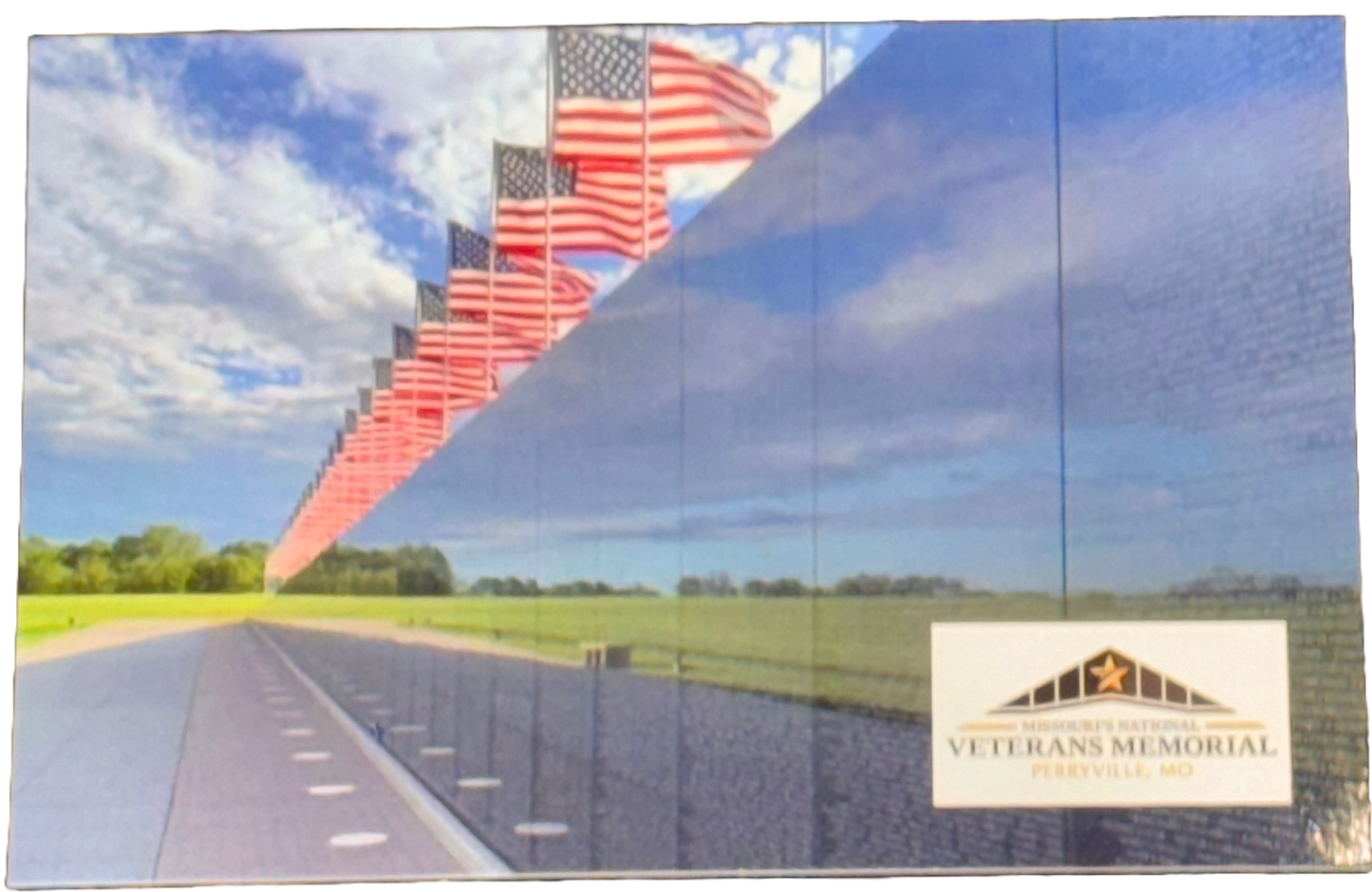 Post Card featuring United States Flags flying above American's Wall, the exact replica of the Vietnam Veterans Memorial wall in Washington DC, at Missouri's National Veterans Memorial. Post card also features Missouri's National Veterans Memorial logo